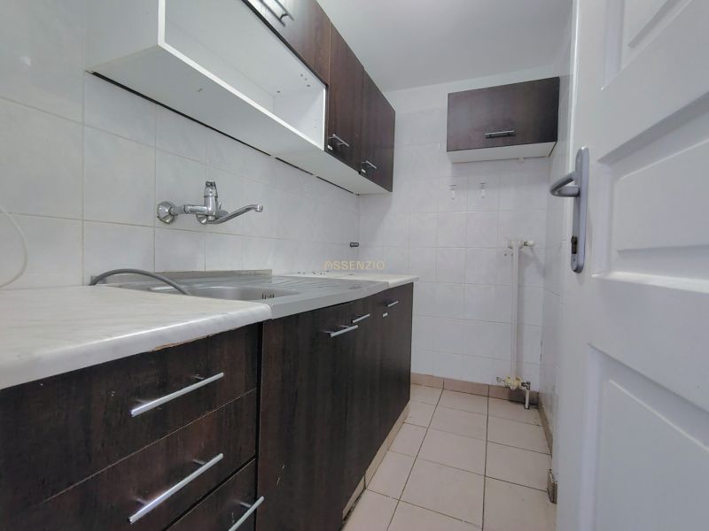 A small kitchen with dark cabinets and tiles, without visible appliances.