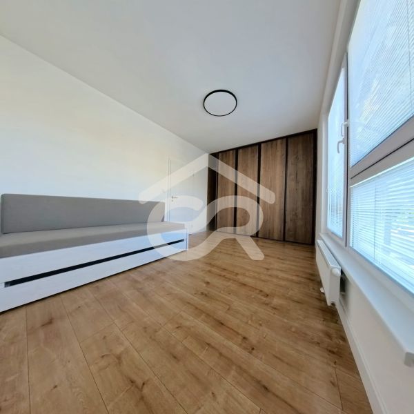 A room in a 3-room apartment with a wooden decor floor and a built-in wardrobe.
