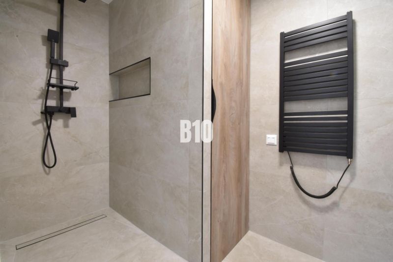 Bathroom in a 4-room apartment with a modern shower and a black radiator.