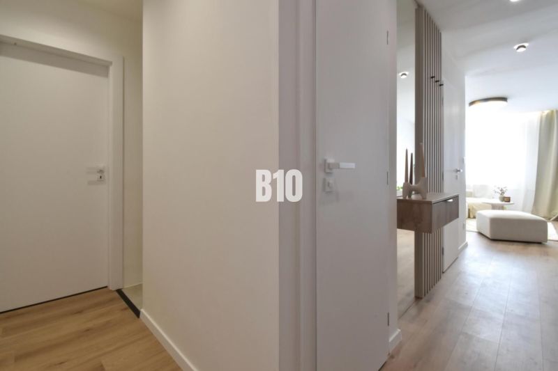 Interior of a 4-room apartment with a wooden decor floor and minimalist furniture.
