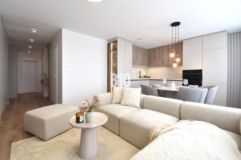 Living room with kitchen in a 4-room apartment, with a wooden decor floor.