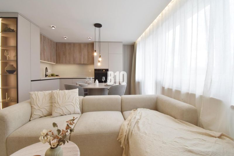 Living room with a kitchenette and a sofa in a 4-room apartment.