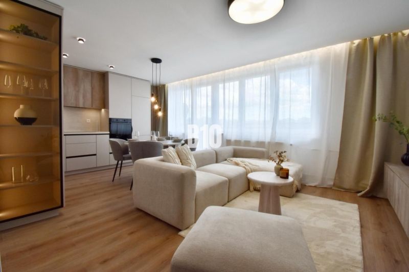 Living room with a light sofa, dining area, and kitchen in a 4-room apartment.