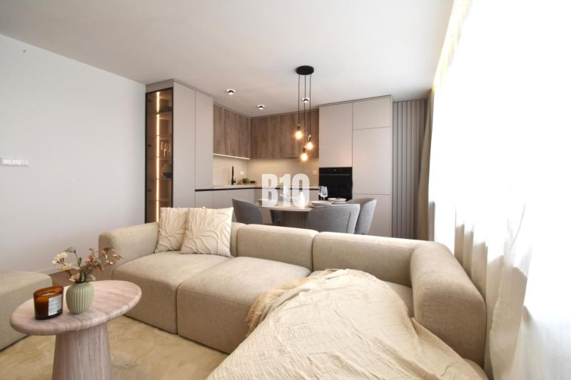 Living room with kitchen in a 4-room apartment with a wooden decor floor.