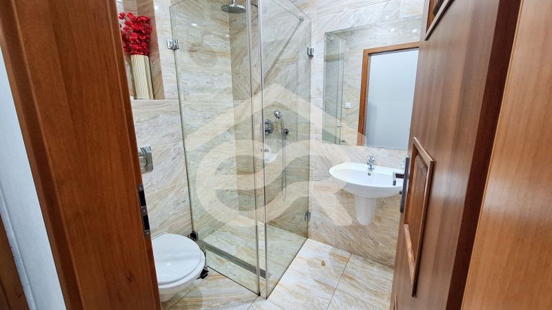 Bathroom with toilet, shower, and decorative flowers in hotels and guesthouses.