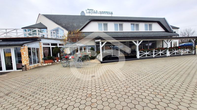 The exterior of the hotel in Veľký Lapáš with a paved courtyard and bicycle decoration.
