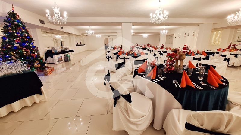 A festively decorated room with adorned tables and a Christmas tree in hotels and guesthouses.