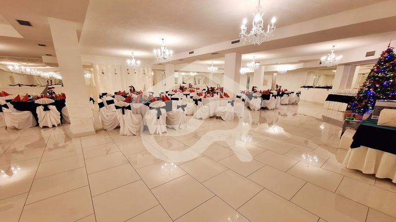 An elegant hall of hotels and guesthouses with decorated tables and a Christmas tree.