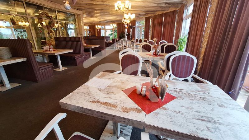 A restaurant with wooden tables, comfortable seating, and decorative lighting in hotels and guesthouses.