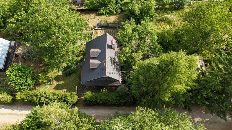 Aerial view of a cabin in Banská Bystrica surrounded by greenery and trees.