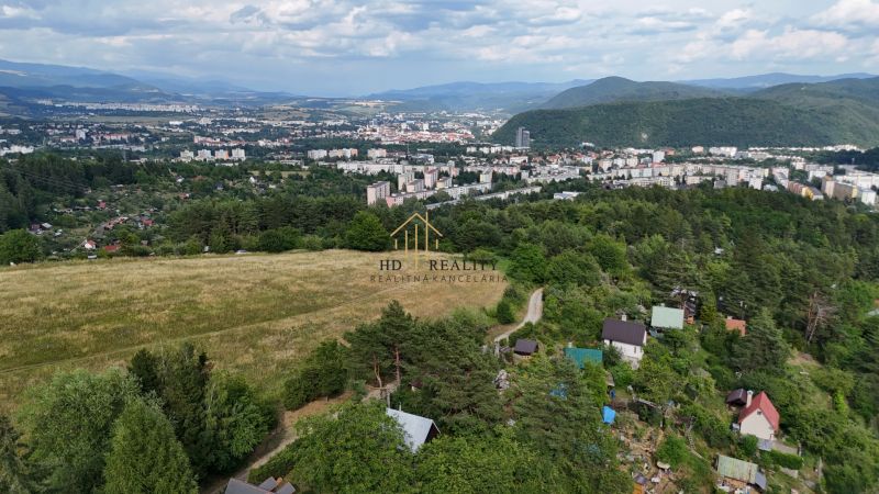 A view of cottages around Banská Bystrica with hills and the city on the horizon.
