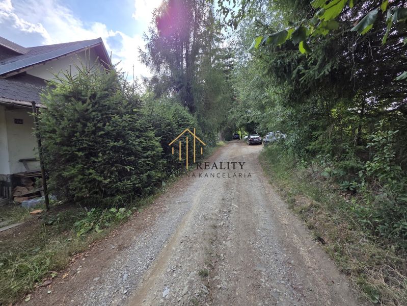 A forest path near a cottage in Banská Bystrica, surrounded by trees and greenery.