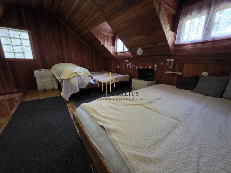 The interior of a wooden cabin with skylights and comfortable beds.