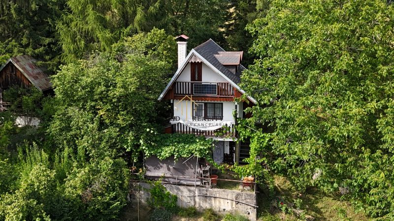 A cottage in the vicinity of Banská Bystrica surrounded by dense trees and greenery.