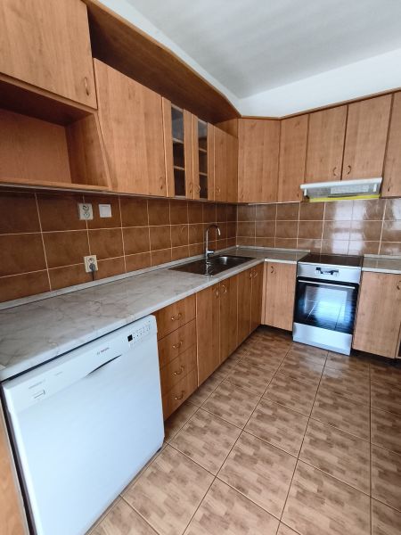 A kitchen with wooden decor in a 3-room apartment, equipped with appliances and cabinets.