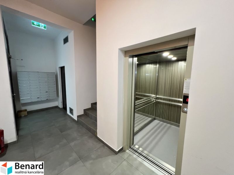Entrance hall with elevator and staircase, tiles, and mailboxes.
