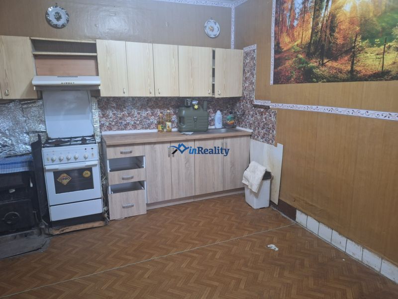 A kitchen in a family house with a wooden decor floor and a stove.