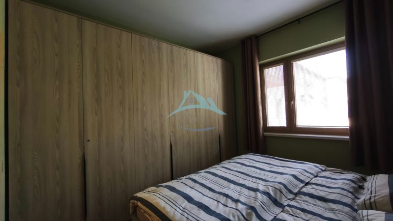 Bedroom in a 2-room apartment with a large wardrobe and a window with blinds.