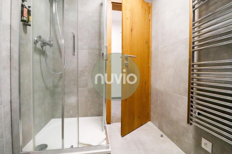 Bathroom in a holiday apartment with tiled walls and a shower corner.