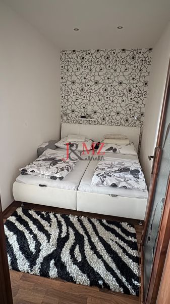A bedroom in a 3-room apartment with a decorative wall and a floor with a wood decor.
