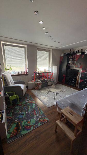 A room in a 3-room apartment with interesting ceiling lighting and a floor with a wooden decor.