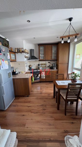 A kitchen in a 3-room apartment with a wood-decor floor and wooden furniture.