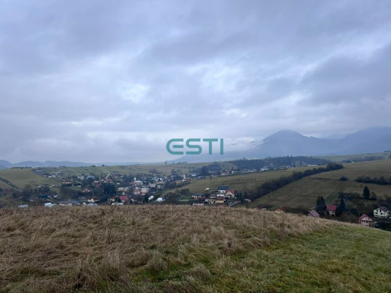 Panorama of agricultural and forest lands in Stránske with a view of the village and mountains.
