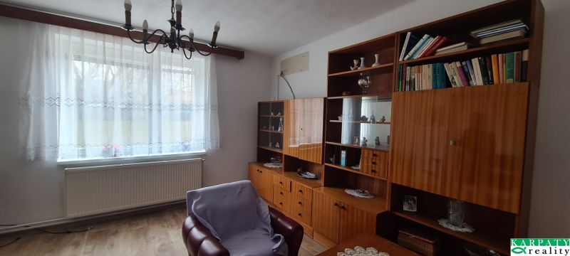 A living room in a family house with retro furniture and a wooden decor floor.