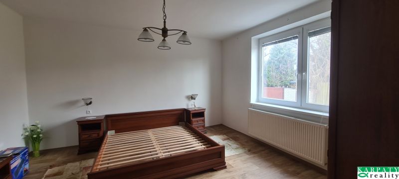 Bedroom in a family house with a double bed, nightstands, and a wooden decor floor.