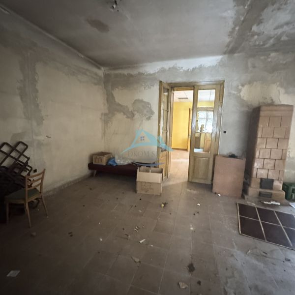 A room with furniture and a tiled stove in commercial premises on the Main Square.