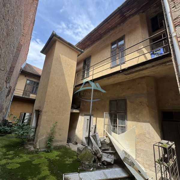 An abandoned building on the Main Square in Šahy with damaged facade and balconies.