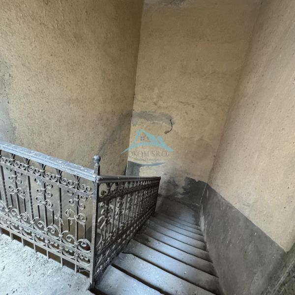 An older staircase with decorative railing in commercial premises.