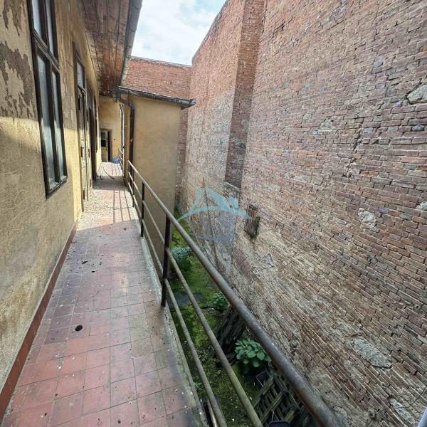 A narrow balcony with a brick wall in commercial premises on the Main Square in Šahy.