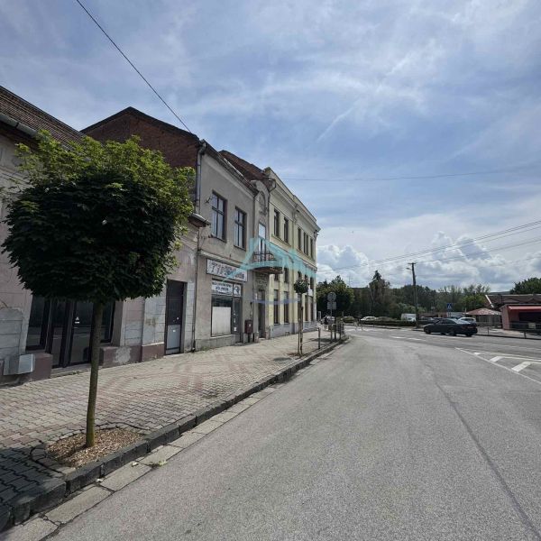 Hlavné námestie Street in Šahy, commercial spaces by the road, with a sidewalk and trees.