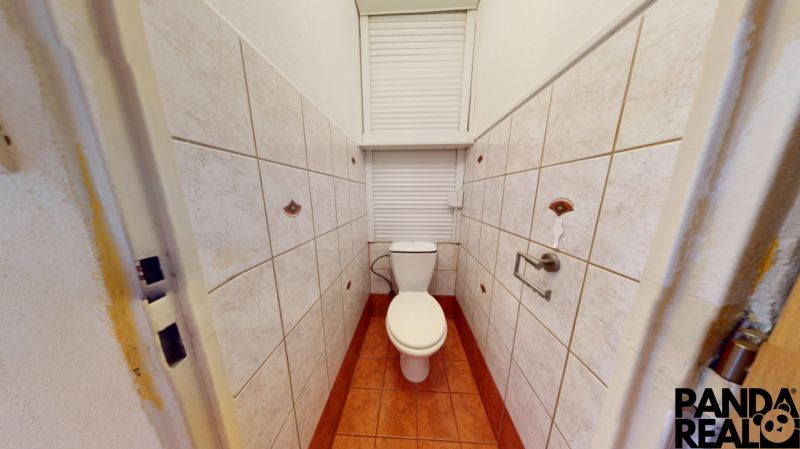 A bathroom with a toilet in a 3-room apartment, tiled with ceramic tiles.