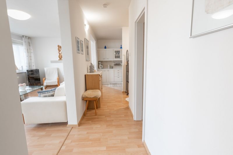 Hallway with entrance to the living room in a 3-room apartment, floor with wooden decor.