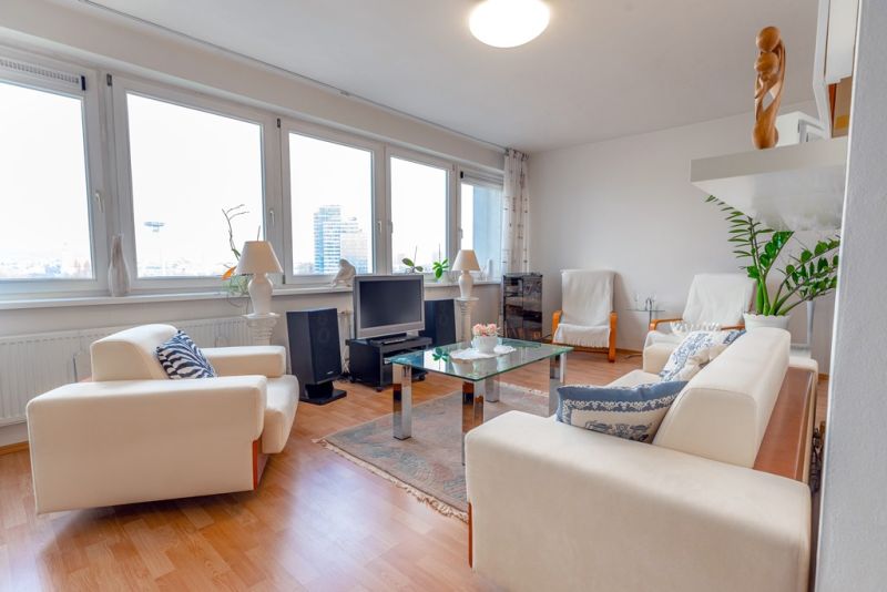 A bright living room with a sofa in a 3-room apartment, wooden decor flooring.