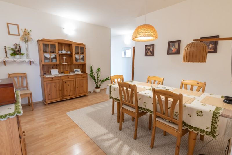 Dining area in a 3-room apartment with wooden furniture and decorations.