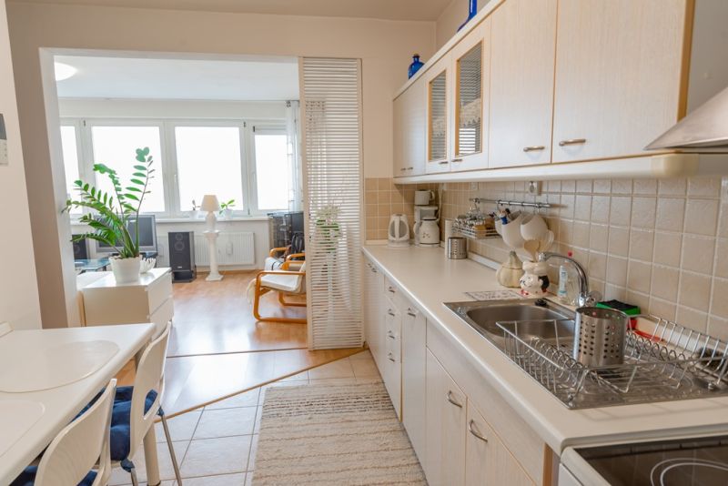 A kitchen in a 3-room apartment with a kitchen unit and entrance to the living area.