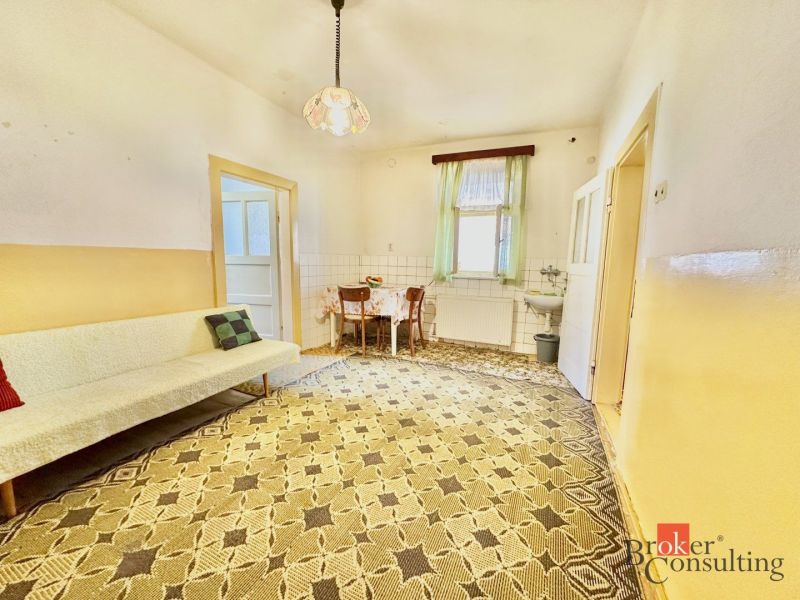 Room with carpeted floor, sofa, and table in a family house.