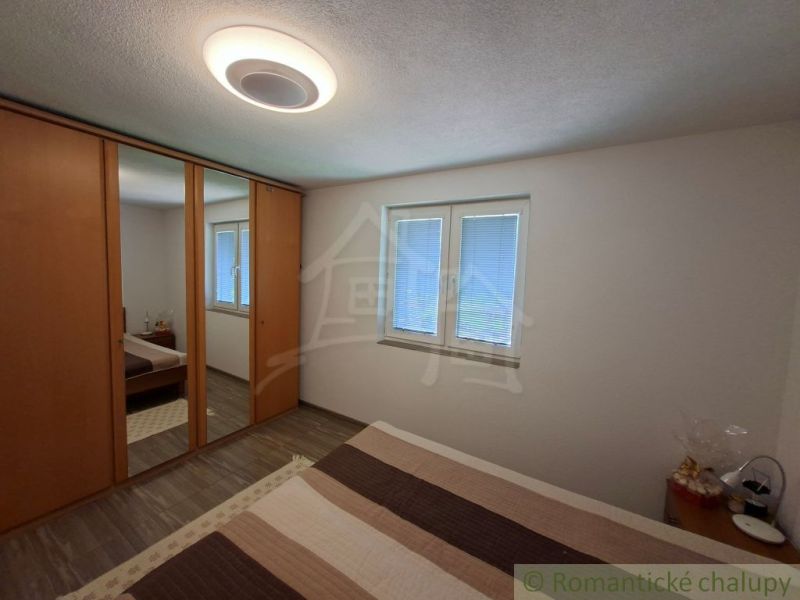 A bedroom in a family house with a large wardrobe and a floor with a wooden decor.