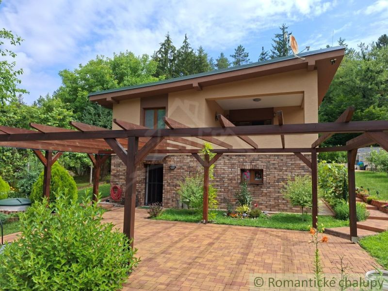 A family house in Veľké Uherce surrounded by a pergola and garden paving.
