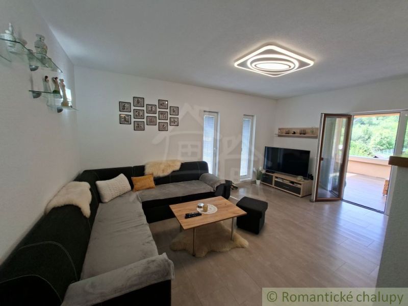 Living room of a family house with a corner sofa and access to the terrace.