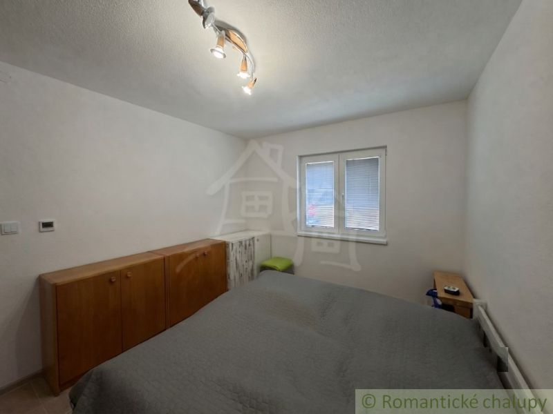 A bedroom of a family house with simple furniture and white walls.