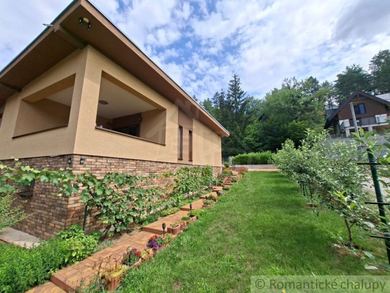 A family house in Veľké Uherce with a landscaped garden and surrounded by greenery.