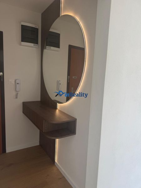 Mirror with LED light and furniture in a 3-room apartment, floor with wood decor.