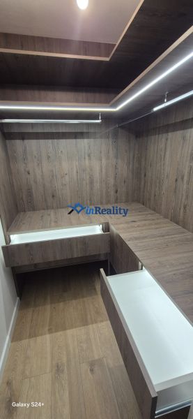 A hallway with a wardrobe and drawers in a 3-room apartment, floor with wood decor.