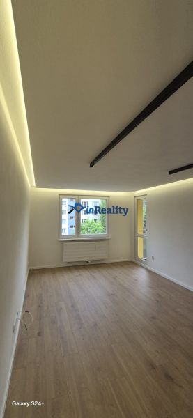 A room with a wooden floor decor and a large window in a 3-room apartment.