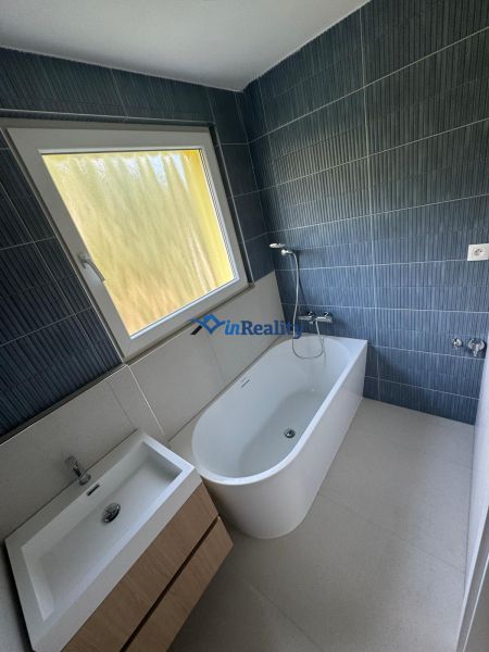 Bathroom in a 3-room apartment with a bathtub, sink, and dark walls.