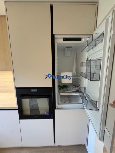 A kitchen in a 3-room apartment with a built-in refrigerator and oven, floor with wooden decor.